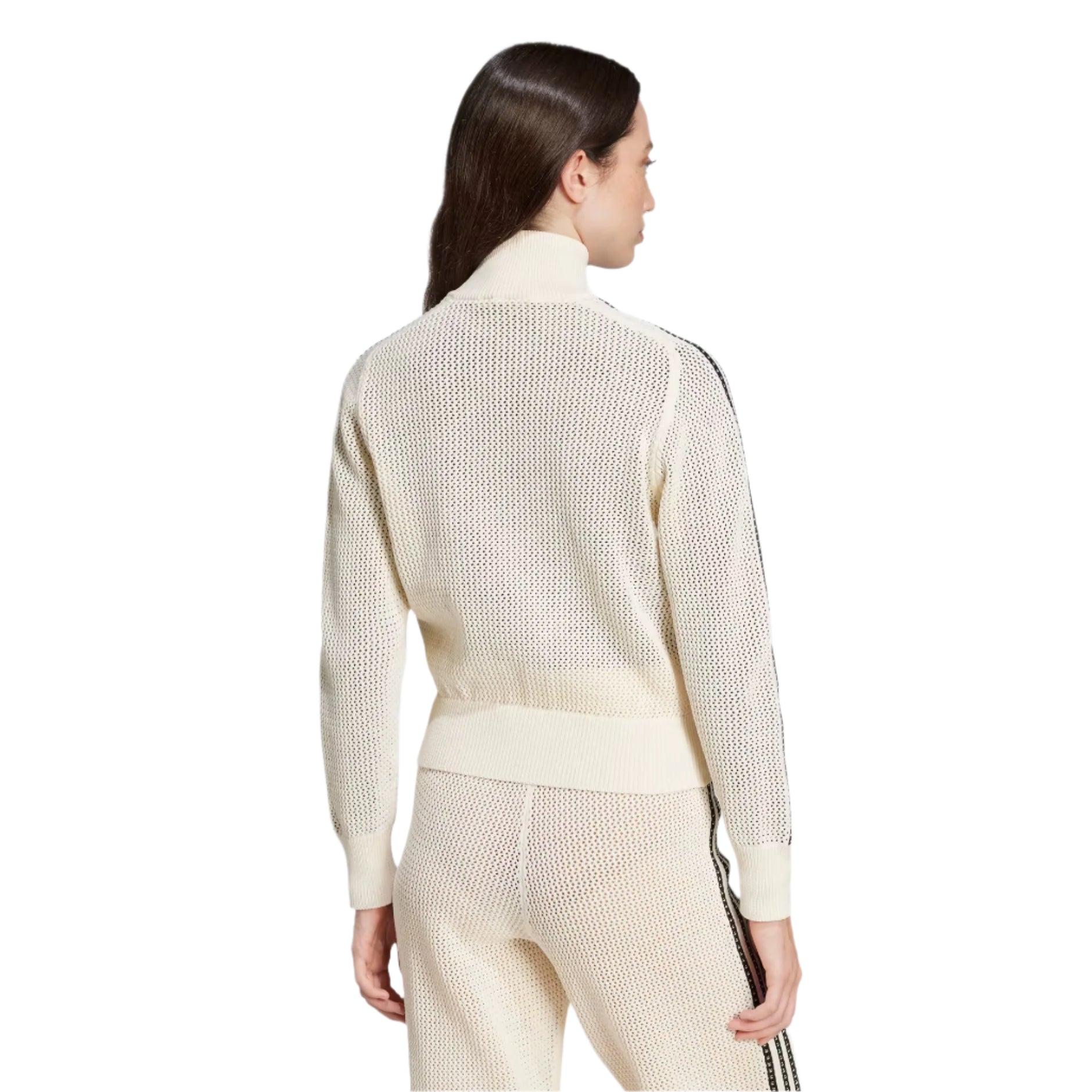 Woman wearing a cream-colored outfit with a textured pattern on a light gray background